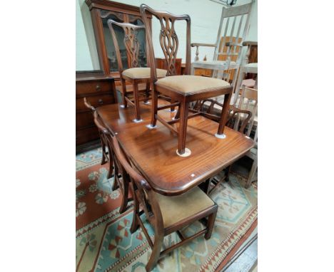 A reproduction Georgian mahogany dining suite comprising rounded rectangular extending twin pedestal dining table, and a set 
