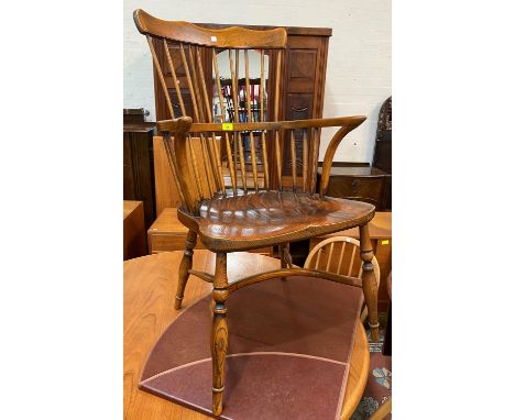 A reproduction distressed oak Windsor armchair with comb back 