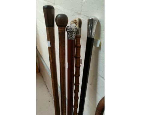 An ebonised walking stick with silver mount; a similar cane; 3 others 