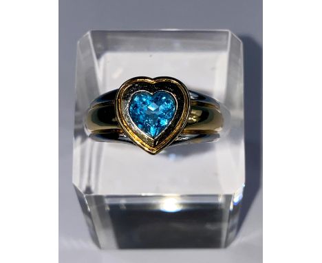 A lady's 18ct hallmarked two tone gold dress ring on a broad shank and blue stone in heart setting, size Q/R 10.6gms 