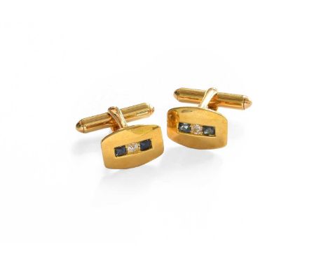 A Pair of Sapphire and Diamond Cufflinks, an old cut diamond flanked by fancy cut sapphires to a yellow plain polished surrou