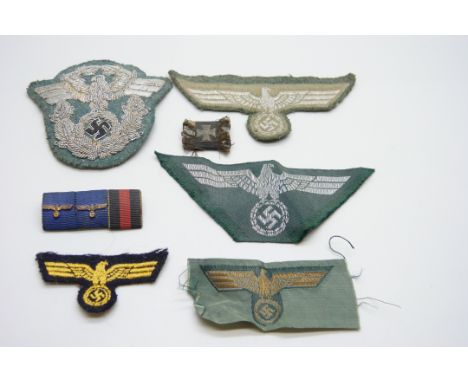 Five German WWII uniform patches, a ribbon bar and one other ribbon bar or badge, including a WWII Police officer's sleeve ea