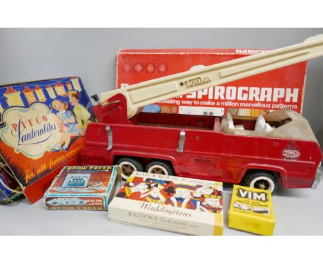A large collection of vintage toys in a suitcase including a large 1970s fire engine, 1950s lanterns, Pelham puppets, Meccano