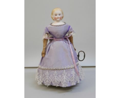 A Victorian automaton, a clockwork walking bisque doll with leather arms, the underside marked, "Patented July 15th, 1862; al