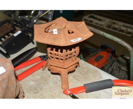 A cast iron pagoda shaped garden light holder