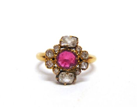 A RUBY AND DIAMOND CLUSTER RING the oval cut stone, approximately 6.5mm by 6mm by 1.6mm deep, with an oval old cut diamond ab