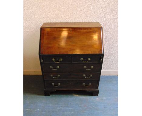 A CROSSBANDED MAHOGANY BUREAU the well fitted interior above two short and three long drawers on bracket feet, 76cm wide 47cm
