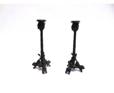 A PAIR OF 19TH CENTURY BRONZE CANDLESTICKS  the sconces modelled wth rams heads and grapes, the bases with three lions, 23cm 