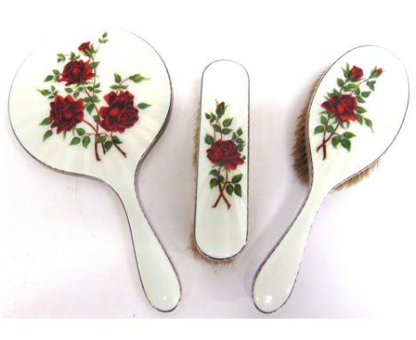 A THREE PIECE ENAMEL AND SILVER DRESSING TABLE SET  Birmingham 1958, comprising a hand mirror, hair brush and clothes brush, 