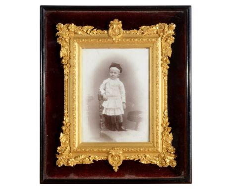 A VICTORIAN PHOTOGRAPHIC PORTRAIT OF A YOUNG BOY  attractively framed in a glazed ebony case enclosing a foliate moulded gilt