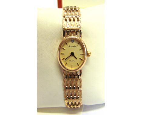 ACCURIST, A LADY'S 9 CARAT GOLD BRACELET WATCH the oval dial set with a small diamond, quartz movement, in original burr wood