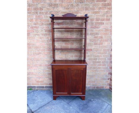 AN EDWARDIAN MAHOGANY BOOKCASE  fitted with open shelves above cupboard base on bracket feet, 77cm wide 32cm deep 86cm high