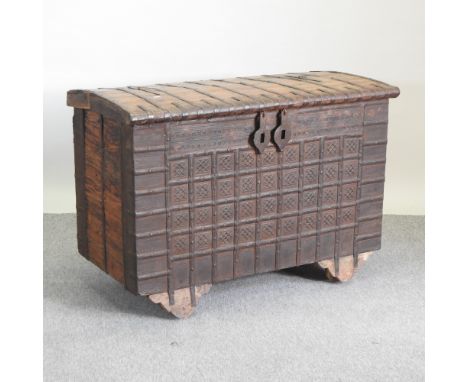 An Indian iron bound hardwood trunk, with a hinged lid, on wheels, 115cm