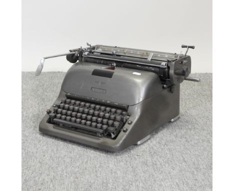 A vintage metal typewriter, together with a wooden spinning wheel