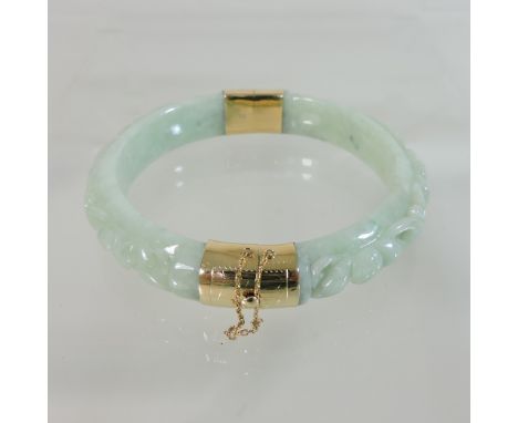 A 14 carat gold mounted carved jade bangle, boxed