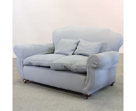 A 1920's blue upholstered sofa, on bun feet, 149cm