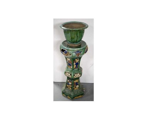 An early 20th Century Majolica jardiniere stand, of chinoiserie design, the circular top over a pierced knopped pillar suppor