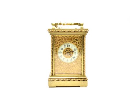 A 19th Century brass cased carriage clock, the Arabic enamel dial within turned column supports, the sides with pierced scrol