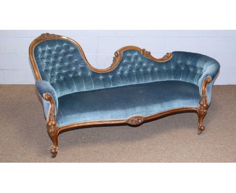 A Victorian carved walnut button back sofa, the shaped back frame carved with leaf and scroll detail, the back and serpentine