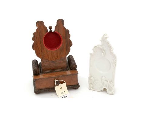 A 19th Century rosewood pocketwatch stand, the shaped receiver above fluted base and underlying drawer; together with ceramic