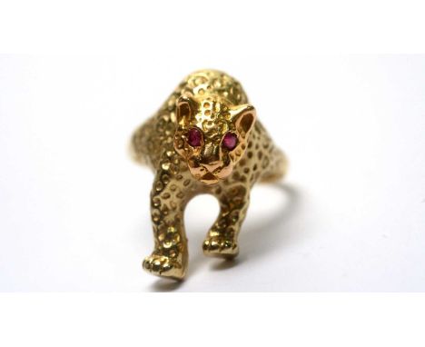 An 18ct yellow gold panther pattern ring, set with ruby eyes, ring size Z, 15.1g gross. 