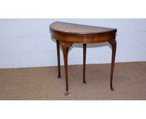 A mid 20th Century burr walnut and banded demilune card table, in an 18th Century style, the hinged and folding top opening t