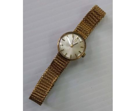 A 1960's ladies Omega dress watch with baton markers, champagne dial with 9ct gold case and mesh bracelet strap, hallmarked a