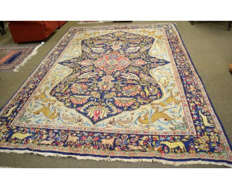 Kirman carpet, South East Iran, the indigo field of scrolling vines around a strawberry medallion enclosed by spandrels and i