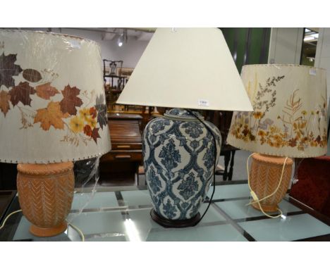 A Chinese style large ceramic table lamp; a pair of unglazed ceramic vase table lamps and three handmade parchment shades 