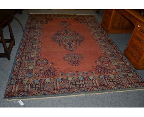 Khotan carpet, East Turkestan, the terracotta field with central medallion framed by spandrels and compartmentalised borders,