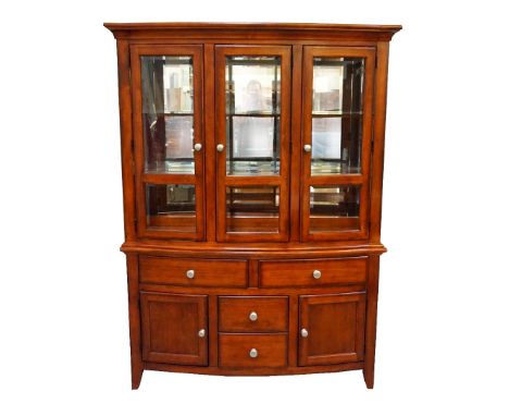 LARGE CHERRY WOOD BOW FRONT DISPLAY CABINETwith a moulded top above three bevelled glass doors opening to reveal an illuminat