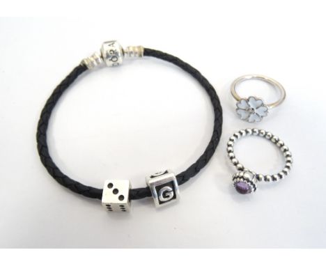 PANDORA BLACK BRAIDED BRACELETwith two charms; together with two Pandora silver rings, one a February birthstone ring set wit