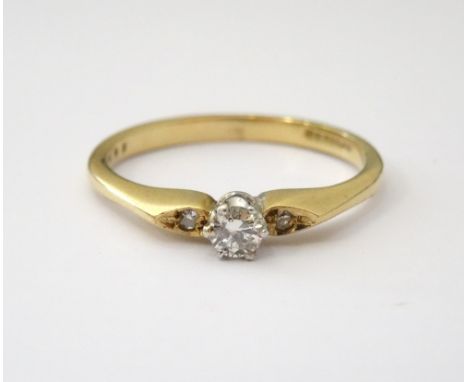 DIAMOND SET DRESS RINGset in nine carat gold, approximately 0.10 of a carat and flanked by two smaller stones, size K-L