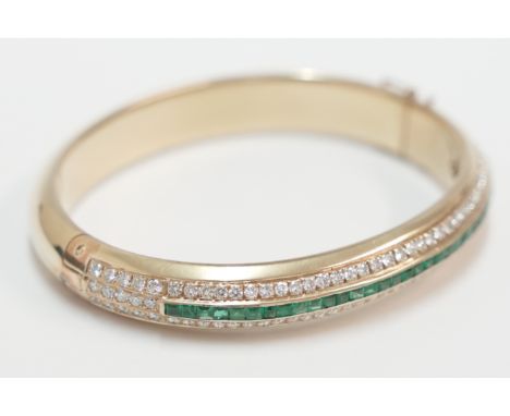 14ct yellow gold bangle, set with centre row of small square Emeralds, approx. 1.00ct total weight, with a row of 45 brillian