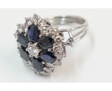 White gold cluster ring, set with centre round Diamond, approx. 0.25ct, surrounded by 6 oval Sapphires, surrounded by further