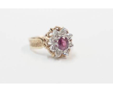 18ct yellow and white gold ring, set with centre oval Ruby, surrounded by 8 small round cut Diamonds. Size K. Total item weig