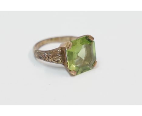 18ct yellow gold ring with carved shoulders, set with single Octangular Peridot, approx. 6.69cts. Size L. Total item weight a