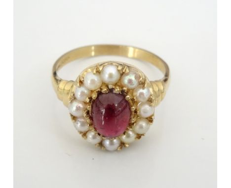 GARNET AND PEARL CLUSTER DRESS RINGthe central oval cabochon garnet in twelve pearl surround, on nine carat gold shank, ring 