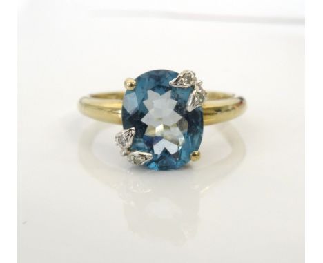 BLUE TOPAZ AND DIAMOND DRESS RINGthe oval blue topaz with small diamonds set to two diagonal corners, on nine carat gold shan