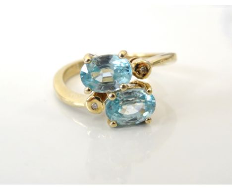 AQUAMARINE AND DIAMOND TWIST DESIGN RINGset with two oval cut aquamarines totalling approximately 1.5cts and two small diamon