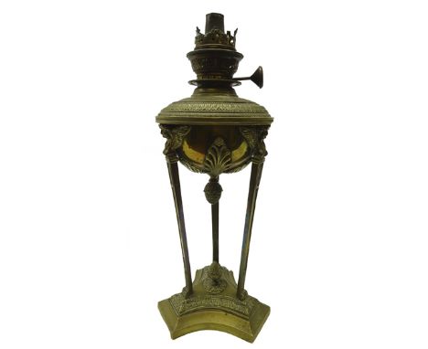 19th century French Neoclassical style brass oil lamp, decorated with three figural winged masks, the reservoir applied with 