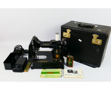 A vintage Singer Featherweight Convertible sewing machine, model 222K contained in carry case. [W]