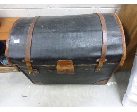 An antique leather domed topped trunk .