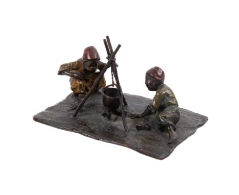 An early 20th century Austrian cold painted bronze figural group. Modelled as two individuals beside a campfire, unsigned, le