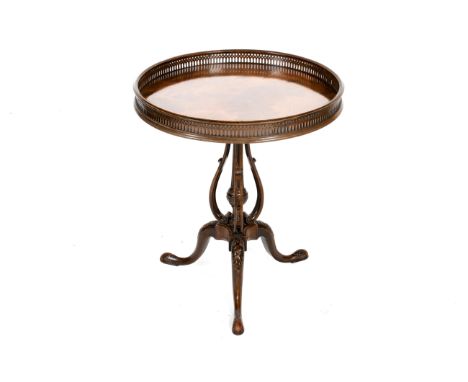 A 19th century mahogany tripod table. The circular top with a pierced gallery, on a central turned column and carved tripod s