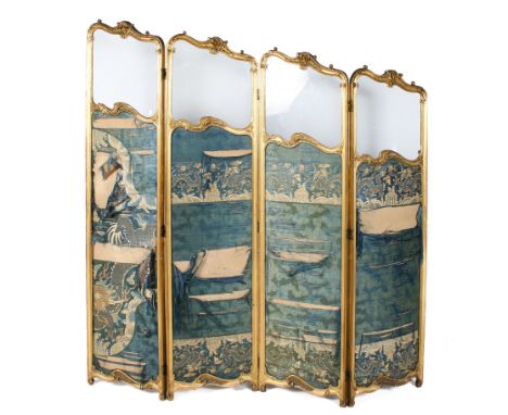 A 20th century folding four panel screen. The carved and moulded gilt frame with scroll details and bearing a plaque reading 