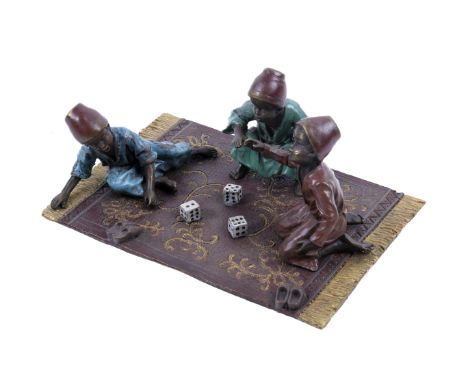 A Bergman Austrian cold painted bronze figural group. Modelled as three figures rolling dices, seated on a carpet, dice playe