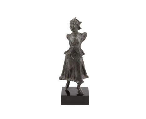 A late Hellenistic style bronze figure of a striding maenad. The female follower of Dionysus is depicted looking to the right