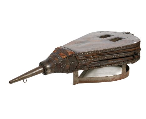 An unusual coffee table. Constructed from a large pair of 19th century stained oak, leather and metal studded blacksmith's be