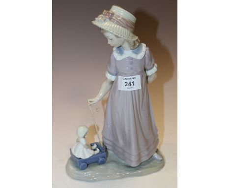 A BOXED FIGURE OF A GIRL PLAYING WITH HER DOLL